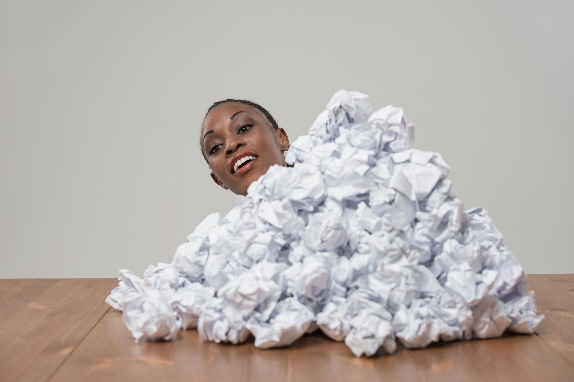 Femme d'affaires africaine avec froissé tas de documents au lieu de travail